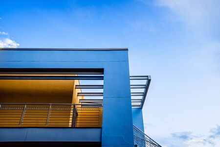 Roof of a blue painted straight design building behind a clear and clear sky at sunset.の写真素材