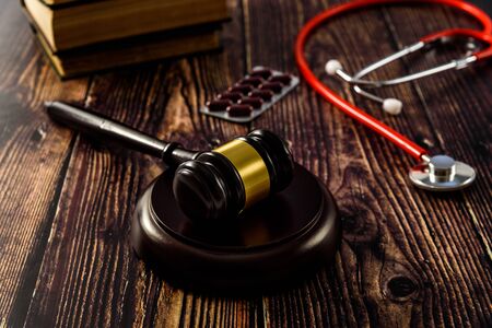 Medical malpractice and errors makes doctors and patients go to court, gavel on legal books.の写真素材