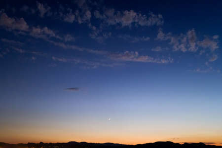 Beautiful sunset behind the mountains with the dark sky and romantic atmosphere.