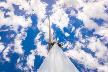 High modern windmills spinning to generate electricity viewed from below.の写真素材