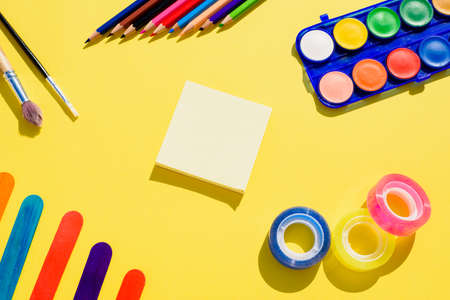 An empty note in the center of a colorful background with school supplies.の写真素材