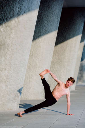 Vasisthasana on the cement of the city, yoga posture to exercise the core.