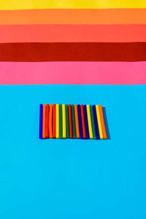 Colorful background of plastic bars, silicone glue, on a background of colored lines.