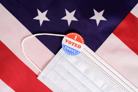 Face mask of a proud voter during the democratic elections in the USA with stickers on the patriotic American flag.の写真素材