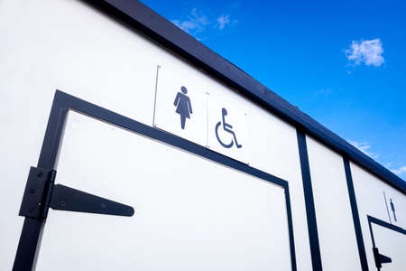 White portable toilets with space for women, men and disabled people.