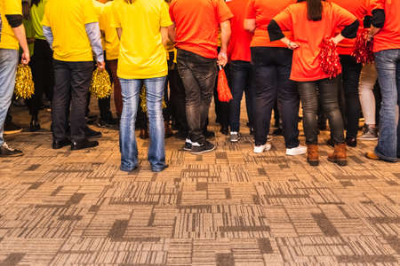 Group of back people with yellow and red colored pom poms.の写真素材