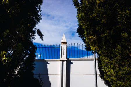 Exterior view of the walls of a religious cloistered convent, surrounded by trees and cypresses.の写真素材
