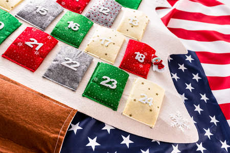 Traditional advent calendar with December 24 in the foreground over American flag