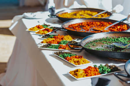 Tasting plate with various types of typical Valencian rice paellas, Spanish food.