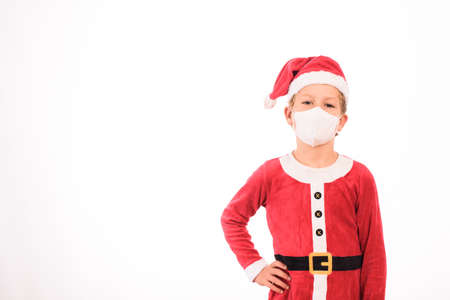 Blond child dressed as Santa Claus and sanitary mask isolated on white background and copy space.の写真素材