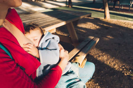 Baby breastfed in a park in the sun.の写真素材