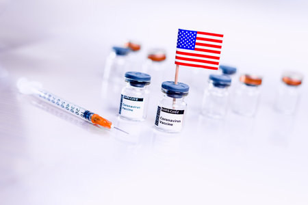 Vials of the coronavirus vaccine with the American flag to cure Covid-19.の写真素材