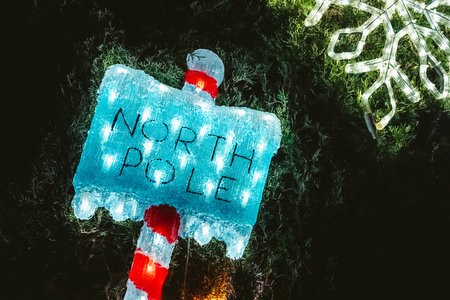 The North Pole is where Santa Claus lives, a sign indicating direction.の写真素材