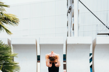 Portrait of a young man practicing yoga doing a concentrated Ustrasana, Camel Pose or back bending...