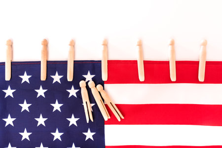 American flag fastened with clothespins on a white background, copy space for text.