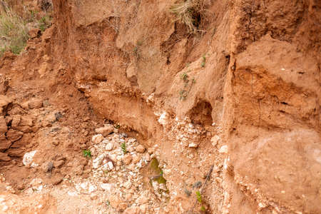 Frontal detail of different strata and layers of rock and earth on a slope.