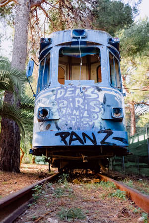 Old tram abandoned and vandalized in a park by young graffiti artists.の写真素材