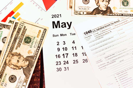 Dollar bills on a calendar with Tax Day, May 17, 2021.の写真素材