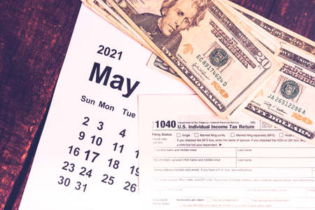 Dollar bills on a calendar with Tax Day, May 17, 2021.の写真素材