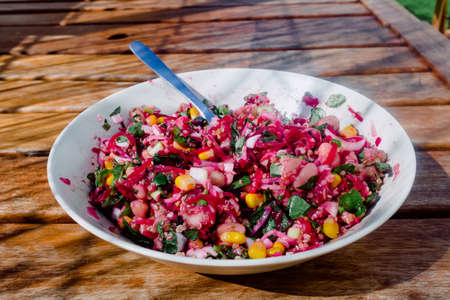 Vegetable and legume salad on a table in the sun.の写真素材