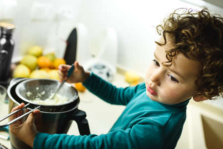 Young baby girl helps prepare a cake using a food processor.