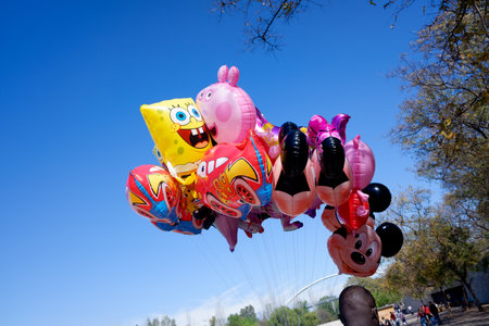 Valencia, Spain - April 15, 2021: Several helium balloons with motifs of children's characters sold by an immigrant.のeditorial素材