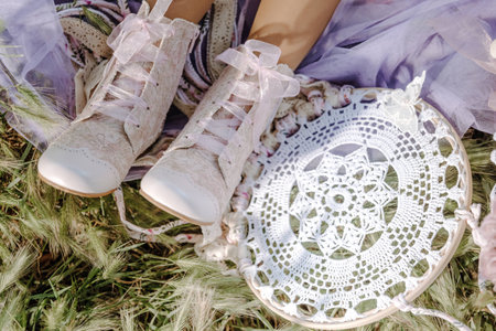 Boots on the feet of a girl who rests in the fresh grass next to a dreamcatcher charm.の写真素材