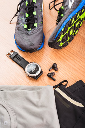 Valencia, Spain - May 9, 2021: Brooks running shoes and Garmin sports watch, top brands in sports equipment, on the floor before an athletics race.のeditorial素材