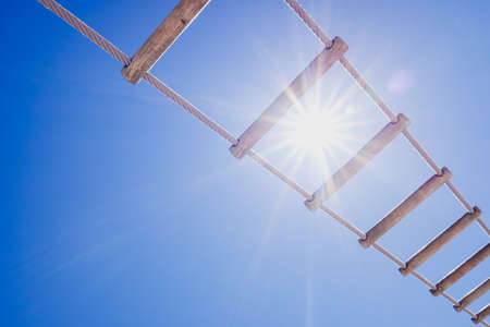 Wooden ladder of an old ship against the midday sun and blue sky background.の写真素材
