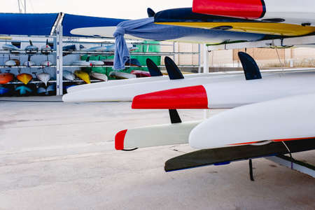 Kayak fins stacked out of the water in the warehouse of a sailing school.の写真素材