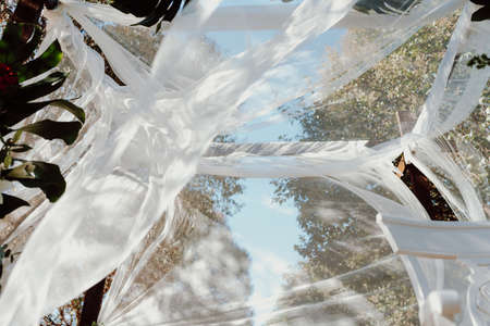 Decorated at a wedding, with a canopy of floral arrangements and silky muslin.の写真素材