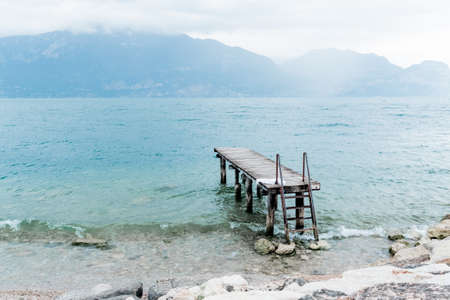 Quiet shore of Lake Garda on a rainy day near the empty jetty.の写真素材