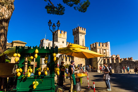 Sirmione, Italy - September 20, 2021: Esplanade at the entrance to Sirmione Castle, a street stall sells traditional lemon juice.のeditorial素材