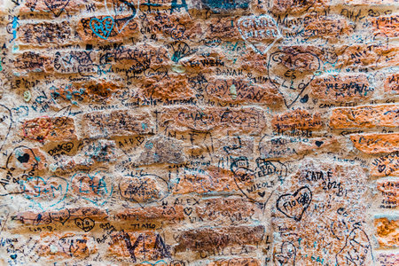 Verona, Italy - September 20, 2021: Stone wall next to Juliet's house, in Verona, where lovers leave their signatures and messages of love.のeditorial素材