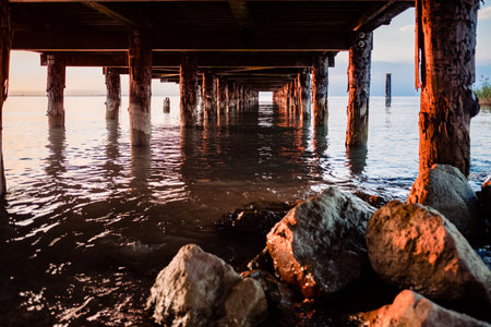 A beautiful sunset on Lago di Garda near the wooden jetty.の写真素材