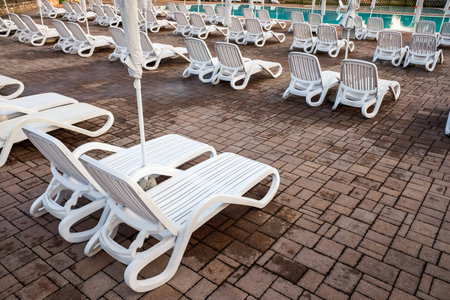 Plastic hammocks near the pool, empty by the end of the summer season.のeditorial素材