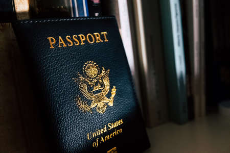 American passport leaning against the dark shelf of a forgotten bookstore.の写真素材