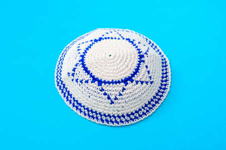 Kippah is a circular hat, with the flag of Israel, isolated on a blue background.の写真素材