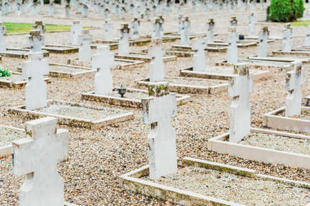 Dozens of marble headstones on nameless white graves in a military cemetery