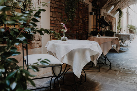 Flirty tables of a cafe in a narrow street, with faded colors and vintage style.の写真素材