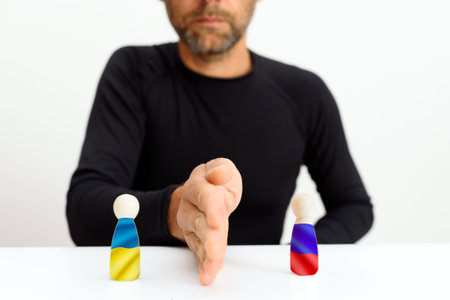 Man separates the position of Ukraine and Russia dividing it with his hand as a metaphor for division.の写真素材