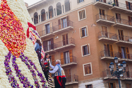 Valencia, spain - March 18, 2022: Falleras deliver bouquets of flowers for the mantle of the Virgen...