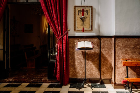 Castril, Spain - March 12, 2022: Interior of a church, where a ray of sunlight illuminates a passage from an open bible on a lectern.のeditorial素材