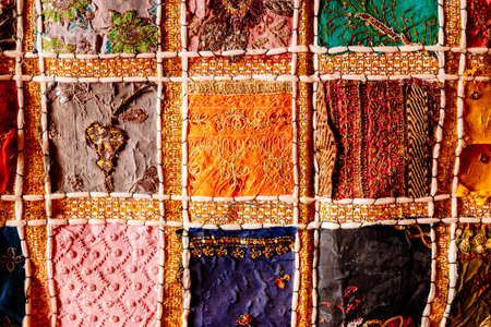 Close detail of colorful handmade embroidery with bright threads from a fabric craft.