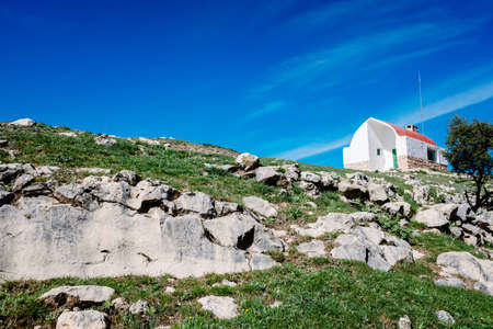 Solid mountain lodge on top of a rocky ridge.