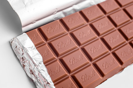 Valencia, spain - april 27, 2022: Lindt swiss chocolate bar with torn foil.
