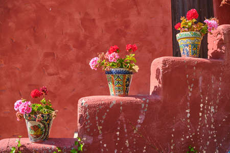 Beautiful vases decorated in a Mexican style, with flowers in the hot summer sun
