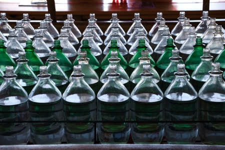 Rows of open glass bottles filled with fresh water