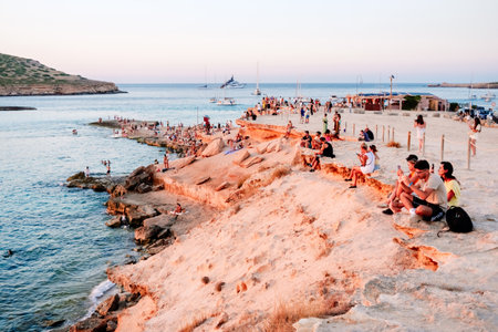 Ibiza, spain - july 28, 2022: Woman enjoys the sunset on the shore of a paradisiacal beach during summer vacations.のeditorial素材