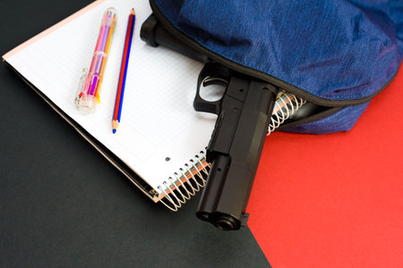 A firearm on the backpack of a young man at school, a loaded gun in a school.